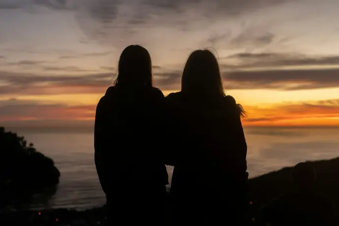 Pareja de mujeres contemplando el atardecer, imagen de atención de pareja lésbica